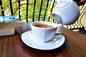 a tea kettle pouring tea into a cup on a table at Park Lane 88 Apartments in Negombo