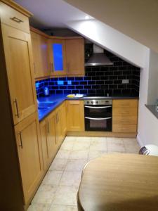 a kitchen with wooden cabinets and a stove top oven at Beautiful Seaview Penthouse Apartment in Bundoran