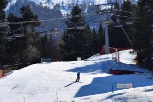 eine Person, die auf einer schneebedeckten Piste mit einem Skilift Ski fährt in der Unterkunft Hotel Sauze in Sauze dʼOulx