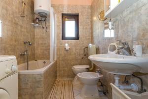 łazienka z umywalką, toaletą i wanną w obiekcie Pool Apartments Julia w mieście Zadar