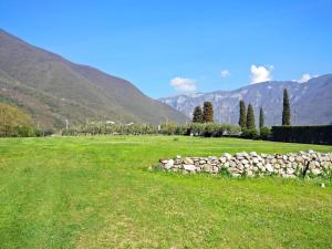 eine Steinmauer in einem Feld mit Bergen im Hintergrund in der Unterkunft B&B Mulino di Campese in Campese