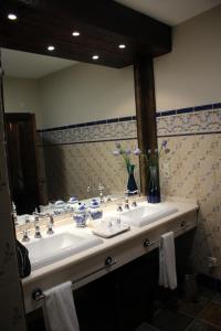uma casa de banho com 2 lavatórios e um espelho grande em Casa Rural Mendoza em Corral de Almaguer