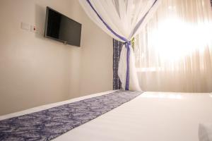 a bedroom with a bed with a curtain and a window at Wida Resort Kilimani in Nairobi