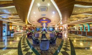 un vestíbulo de hotel con un casino con mesas y sillas en Dizalya Palm Garden Hotel, en Konaklı
