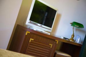 une télévision assise au-dessus d'un meuble en bois dans l'établissement Hotel Le Cave, à Sirolo