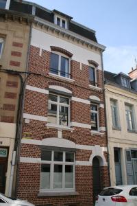 - un bâtiment en briques avec des fenêtres donnant sur une rue dans l'établissement PlacesAppart, à Arras