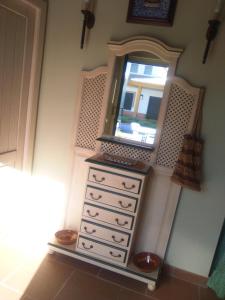uma cómoda com um espelho em cima em Casa Rural Viña Chica em Dos Hermanas