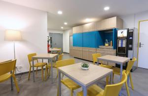 a dining room with tables and yellow chairs at Apparteo Marseille in Marseille
