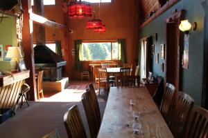 uma sala de jantar com uma longa mesa de madeira e cadeiras em Barnyard Backpackers Te Anau em Te Anau