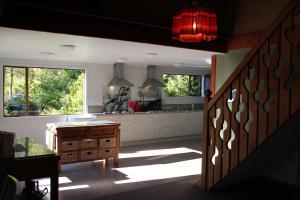 a kitchen with a staircase and a large window at Barnyard Backpackers Te Anau in Te Anau
