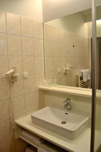a bathroom with a sink and a mirror at Hotel Grazerhof in Bad Gleichenberg