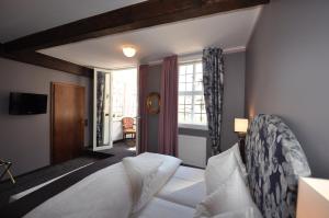 a hotel room with a bed and a window at Hotel Schmuckkästchen in Miltenberg