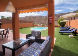 a patio with chairs and a table and a pool at Casas de Tauro in La Playa de Tauro