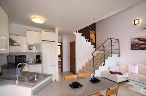 a kitchen and a living room with a staircase at Casas de Tauro in La Playa de Tauro