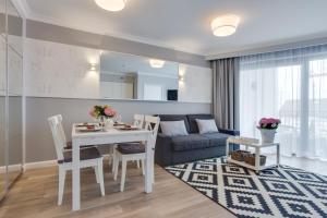 a living room with a table and a couch at Horyzont Luksusowe apartamenty nad morzem z parkingiem Międzyzdroje in Międzyzdroje