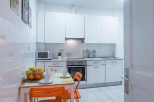 a kitchen with a table with a bowl of fruit on it at Apartamento Urgul in Donostia-San Sebastián