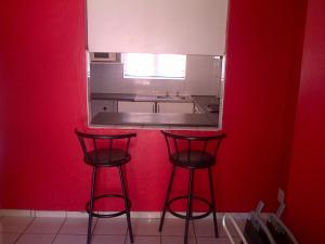 two red stools in a kitchen with a red wall at Durban Accommodation 118 Summersands in Durban