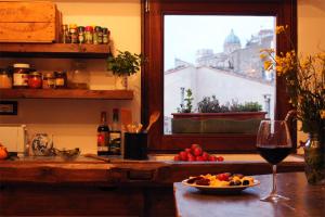 een tafel met een glas wijn en een fruitschaal bij Casa Bella Gangi in Gangi