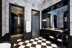 a bathroom with two sinks and a checkered floor at Le Pavillon de la Reine & Spa in Paris