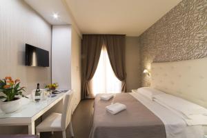 a hotel room with a bed and a desk at Hotel Club in Sant'Agnello
