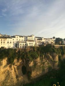 un grupo de casas blancas en un acantilado en Casa Palacio VillaZambra en Ronda