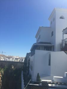 ein weißes Gebäude mit blauem Himmel im Hintergrund in der Unterkunft Casa Palacio VillaZambra in Ronda