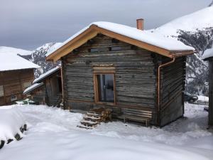 Cabaña de madera con nieve en el techo en Dem Himmel ein Stuck näher, en Thalkirch