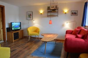 ein Wohnzimmer mit einem Sofa, einem Tisch und einem TV in der Unterkunft Haus Kaspers in Kelberg