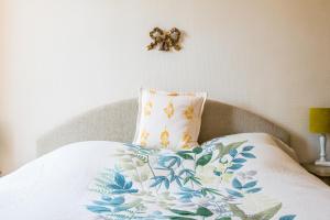 ボーヌにあるChez Barbaraの花の毛布と枕が付いたベッド
