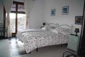 a white bedroom with a bed and a window at Caseria 7 Fuentes in Hinojares