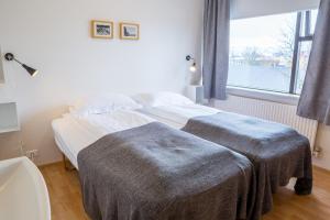 ein Schlafzimmer mit einem Bett mit zwei Decken darauf in der Unterkunft Guesthouse Sunna in Reykjavík