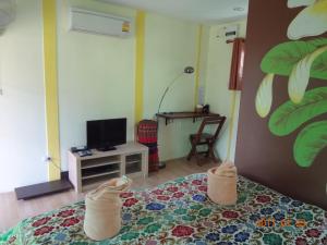 Una televisión o centro de entretenimiento en At Home Sukhothai