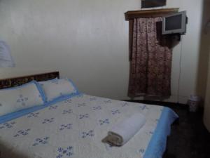 ein Schlafzimmer mit einem Bett und einem Handtuch darauf in der Unterkunft Tooro Resort Hotel in Fort Portal