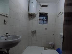 a small bathroom with a sink and a toilet at Tooro Resort Hotel in Fort Portal