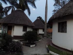 three thatched cottages with their thatched roofs at Tooro Resort Hotel in Fort Portal