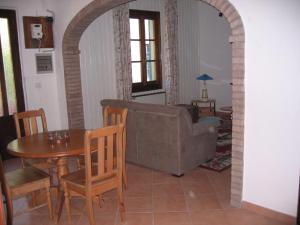 a living room with a couch and a table and chairs at Villa with River Access in Cocciglia