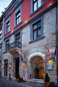 a building on a street with flags on it at Rudolfo Hotel in Lviv