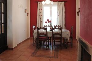 comedor con mesa, sillas y ventana en Casa Gil - La Vega, en El Bosque
