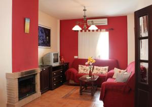 sala de estar con paredes rojas y chimenea en Casa Gil - La Vega, en El Bosque