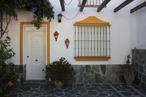 una puerta blanca y una jaula de pájaros en un edificio en Casa Gil - La Vega, en El Bosque