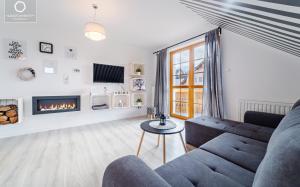 a living room with a couch and a fireplace at Wonder Home - Apartamenty blisko centrum Karpacza, tuż przy szlakach i stoku narciarskim - cicha okolica in Karpacz