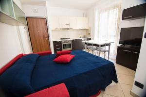 una camera da letto con un letto blu con cuscini rossi di Bilocale Damiani a due passi dal mare a San Benedetto del Tronto