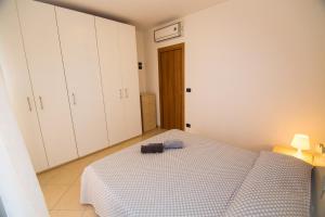 - une chambre avec un lit et des armoires blanches dans l'établissement Bilocale Damiani a due passi dal mare, à San Benedetto del Tronto