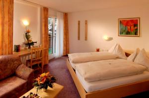 een hotelkamer met een bed en een bank bij Park-Hotel Saas- Fee in Saas-Fee