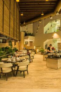 a restaurant with people sitting at tables in a room at The Red Maple Mashal in Indore