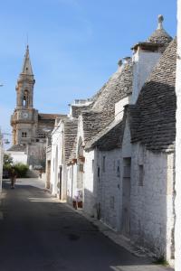una strada vuota con una chiesa sullo sfondo di Trullo Monte Grappa ad Alberobello Altre 2 foto