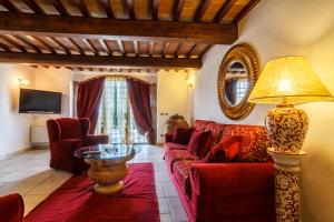 Una sala de estar con un sofá rojo y una mesa. en Villa Teresa, en Cortona