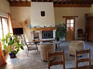 a living room with a fireplace and a table and chairs at Le Moulin Aux Moines in Croissy-sur-Celle