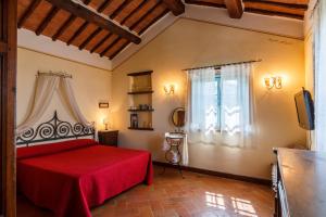 Un dormitorio con una cama roja y una ventana. en Villa Teresa, en Cortona 60 fotos más
