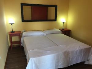 サン・セバスティアン・デ・ラ・ゴメラにあるCasa Reyesのベッドルーム(白い大型ベッド、ランプ2つ付)